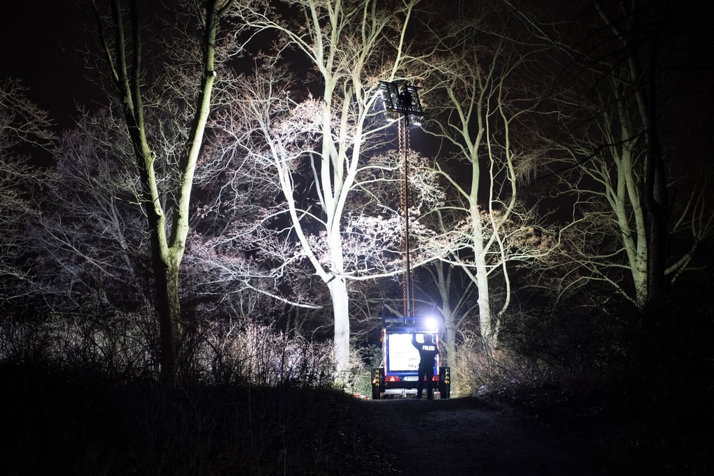 Polizisten beleuchten im Dunkeln einen Ort an einem Park in Pankow. Das vermisste vierjährige Mädchen aus Berlin ist tot. Es sei am Abend mit Verletzungen von Passanten im Bürgerpark Pankow gefunden worden, sagte ein Polizeisprecher.