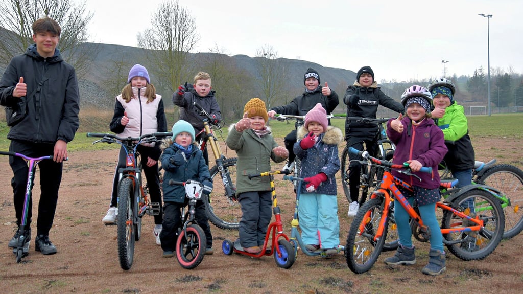 Die Kinder stehen bereit. Auf dieser Fläche soll die Anlage entstehen.