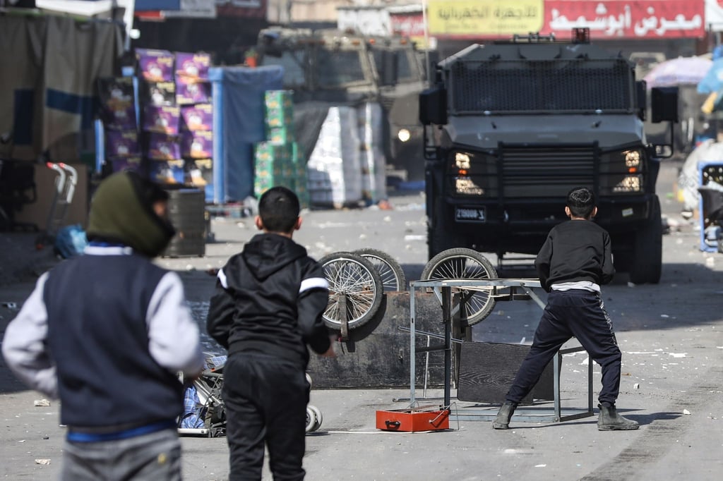 Junge Palästinenser stellen sich in Nablus einem Fahrzeug der israelischen Armee entgegen.