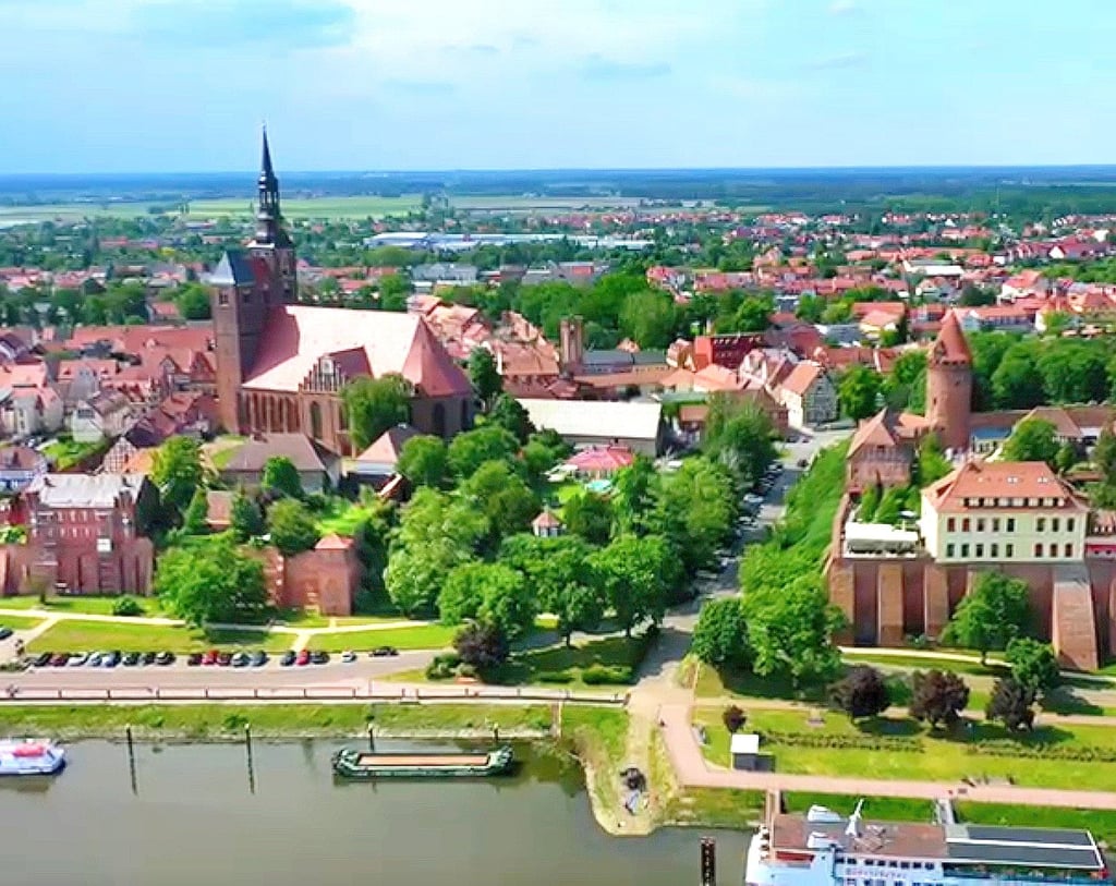 Blick einen Teil der Tangermünder Altstadt mit ihrem Schlosshotel (rechts) auf dem Burgberg hoch über der Elbe, mit einem Teil des Tangermünder Hafens (unten im Foto) und der große nevangelischen Kirche St. Stephan.
