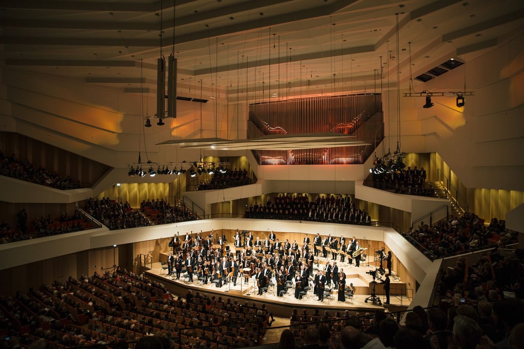 Musiker der Dresdner Philharmonie stehen auf der Bühne des Kulturpalastes.