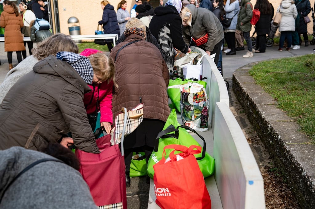 Menschen stehen auf dem Gelände der Arche in Berlin-Hellersdorf, um sich dort mit Lebensmitteln einzudecken.