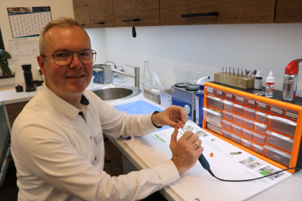 Hörakustimeister Christoph Dunkel glättet in seiner Werkstatt den Silikonohrabdruck einer Otoplastik.