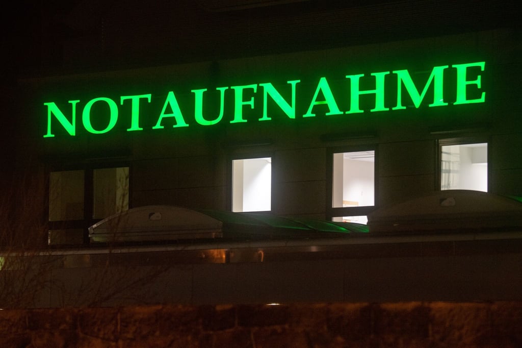 Der Schriftzug „Notaufnahme“ hängt in leuchtendem Grün an einem Krankenhaus.