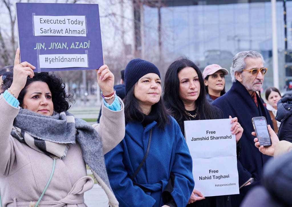 "Free Jamshid Sharmahd - Free Nahid Taghavi" und "Jin, Jiyan, Azadi" steht auf Plakaten, das Demonstrantinnen, darunter Schauspielerin Jasmin Tabatabai (2.v.l) und Filmproduzentin Minu Barati halten.