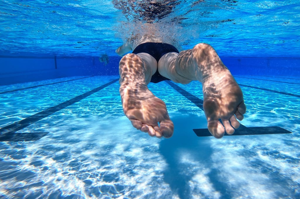 Ein Schwimmer schwimmt durch ein Becken im Freibad.