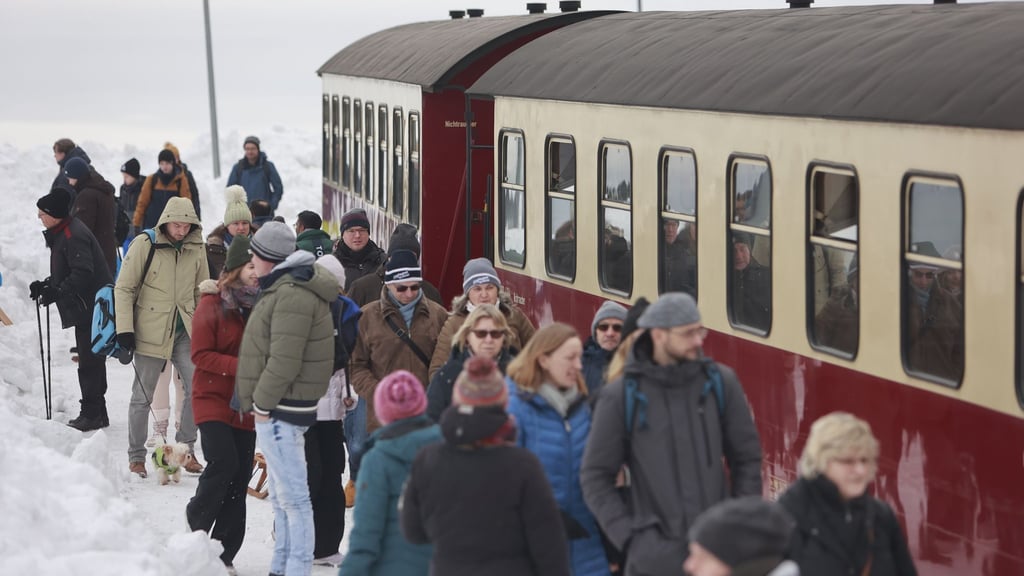 Besucher stehen auf dem Brocken nachdem ein Zug der Harzer Schmalspurbahnen GmbH den Brockengipfel erreicht hat.
