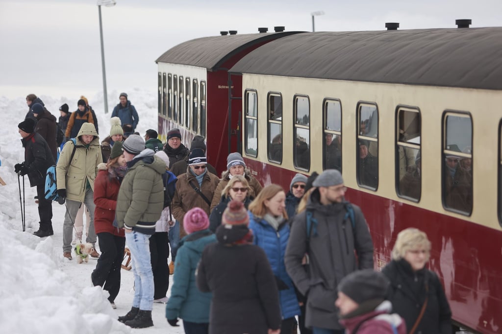 Besucher stehen auf dem Brocken nachdem ein Zug der Harzer Schmalspurbahnen GmbH den Brockengipfel erreicht hat.