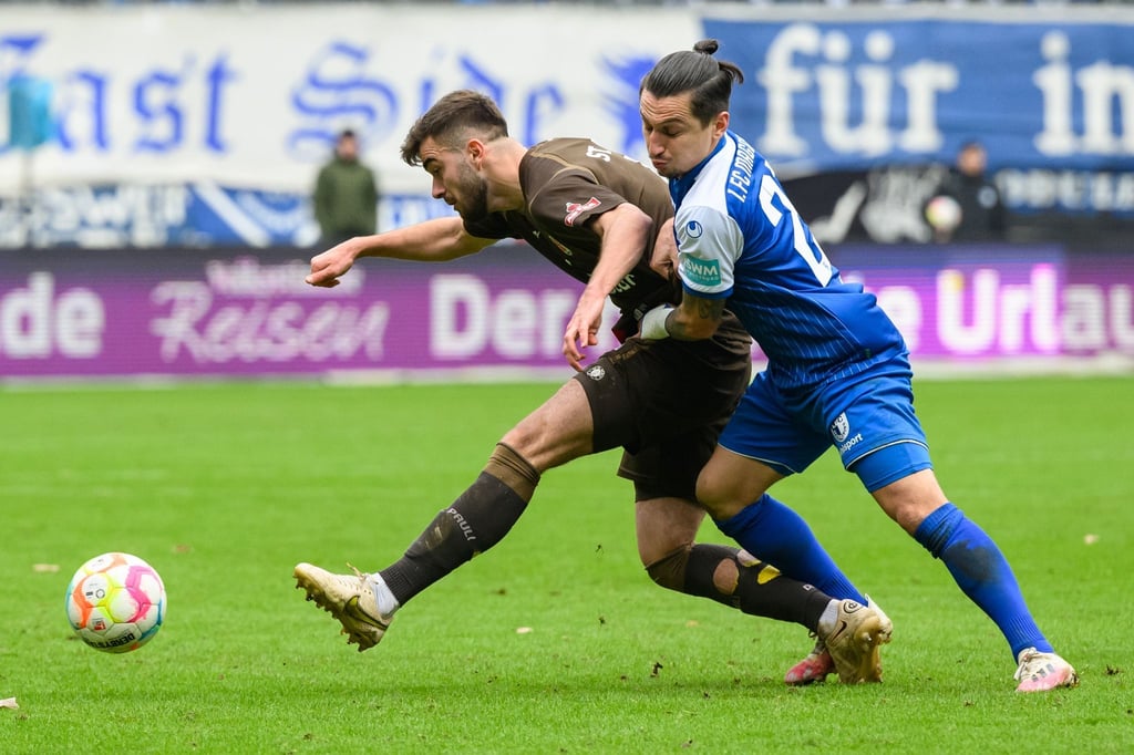 St. Paulis Jackson Irvine (l) setzt sich gegen Magdeburgs Baris Atik durch.