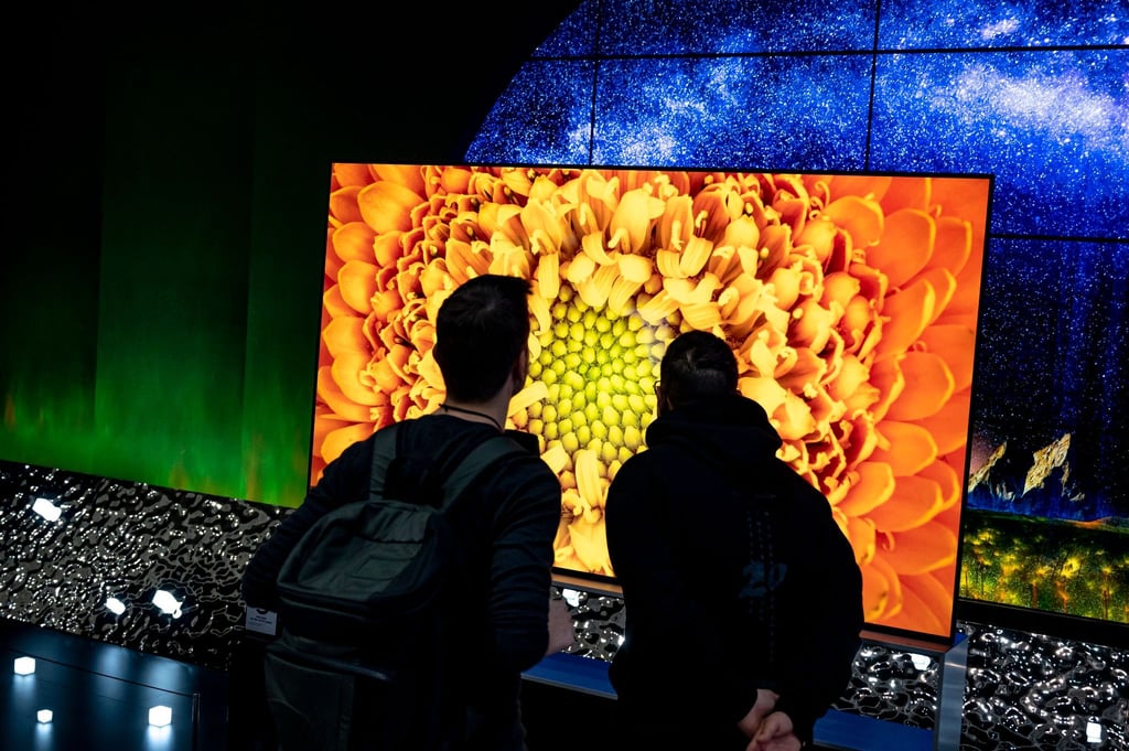 Besucher auf der Elektronikmesse IFA vor neuen TV-Geräten auf dem Stand eines Herstellers.