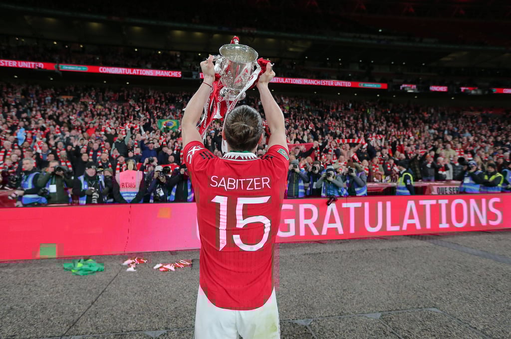 Marcel Sabitzer hält vor der Kurve den Pott in die Höhe.