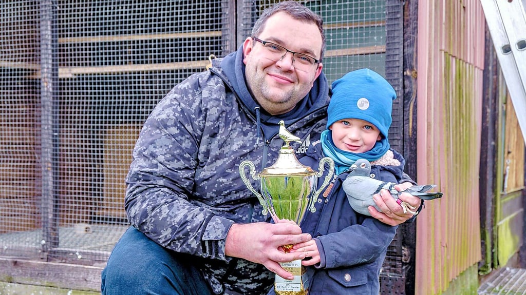 Brieftaubenzüchter Sebastian Stein mit MZ-Pokal, Sohn Marlon und Siegertaube.