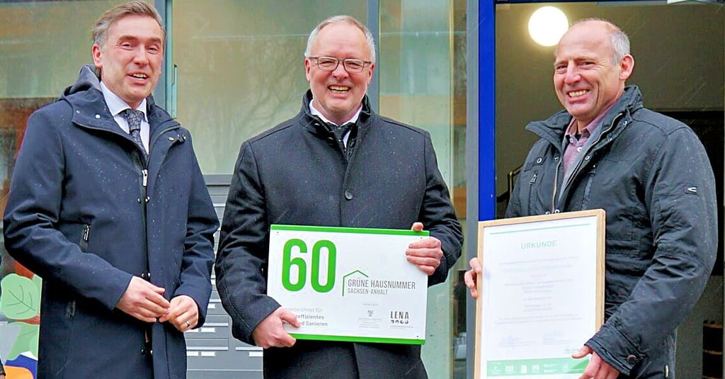 Das individuell angefertigte Hausnummernschild wird Klaus Jaenecke (Mitte) anbringen. Energiestaatssekretär Thomas Wünsch (l.) und Rathaus-Vize Marko Kohlrausch freuen sich mit.