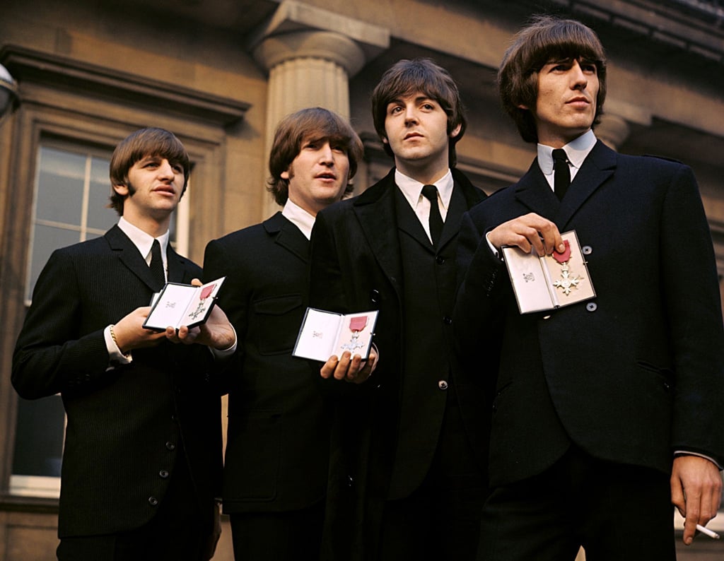 Ringo Starr, John Lennon, Paul McCartney und George Harrison zeigen ihre MBE-Insignien auf dem Vorplatz des Buckingham Palace, nachdem sie von Königin Elisabeth II. empfangen wurden.