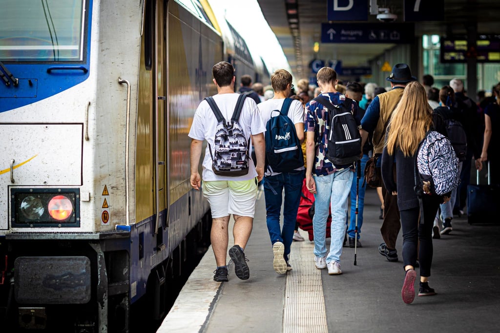 Reisende gehen einen Bahnsteig im Hauptbahnhof Hannover entlang.