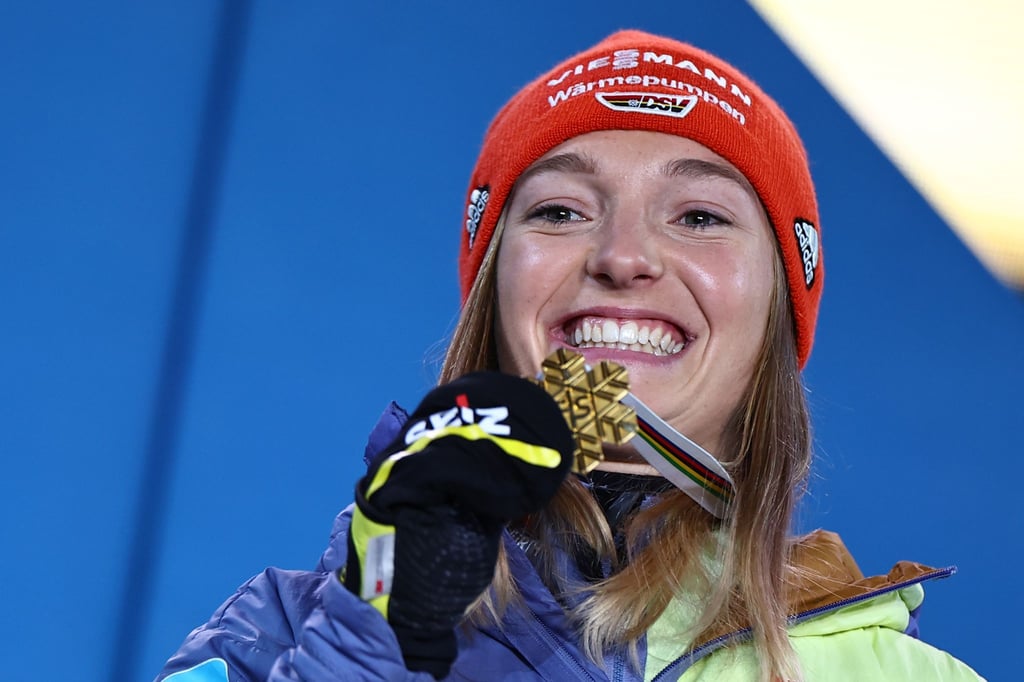 Katharina Althaus präsentiert und ihre WM-Goldmedaille.