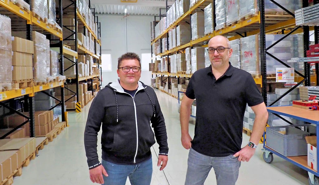 Konrad Freynik (links) und Simon Fröhlich im Hochregallager, in dem vor allem Ersatzteile für den Versand bereit liegen.