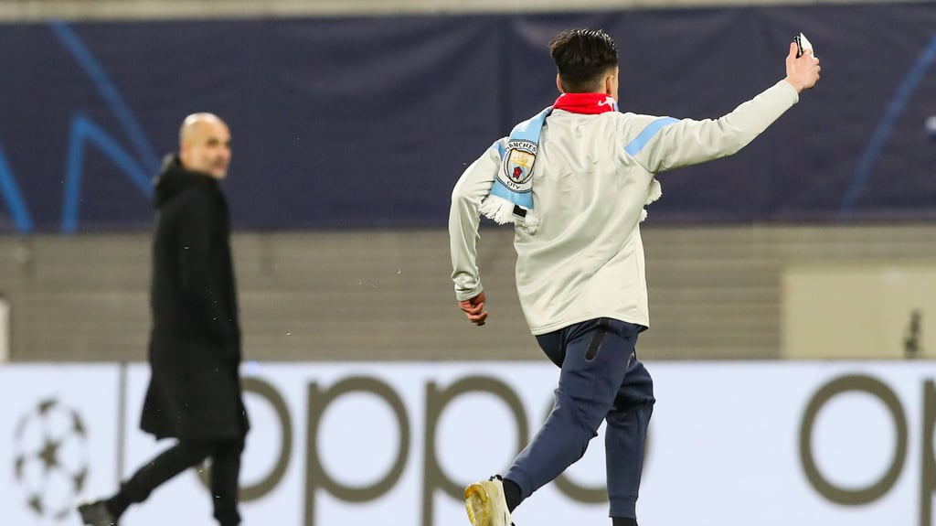 Der Flitzer rennt über den Rasen der Red-Bull-Arena, im Hintergrund verfolgt Man-City-Coach Pep Guardiola die Szene.