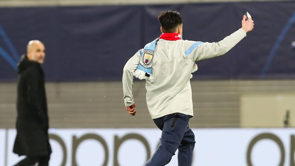 Der Flitzer rennt über den Rasen der Red-Bull-Arena, im Hintergrund verfolgt Man-City-Coach Pep Guardiola die Szene.