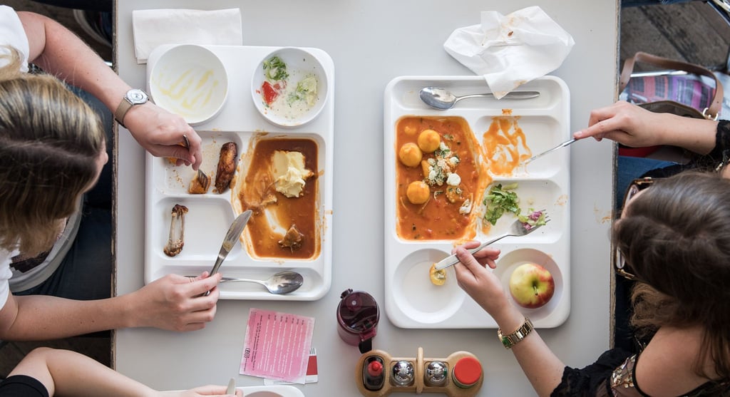 Zwei Studentinnen essen in der Mensa.