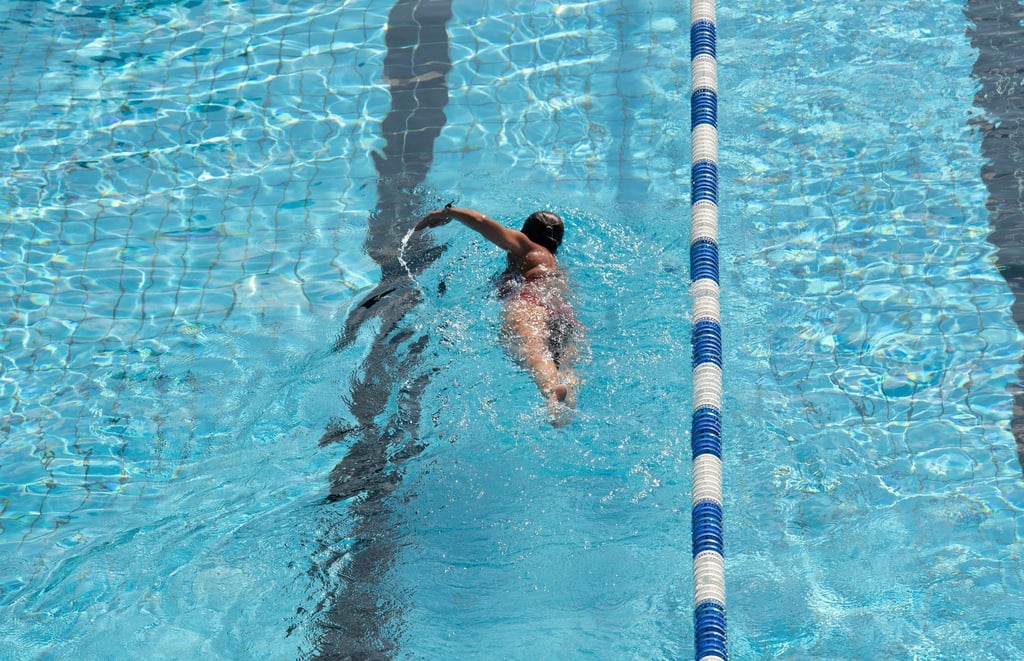 Eine Frau zieht ihre Bahnen in einem Schwimmbad.