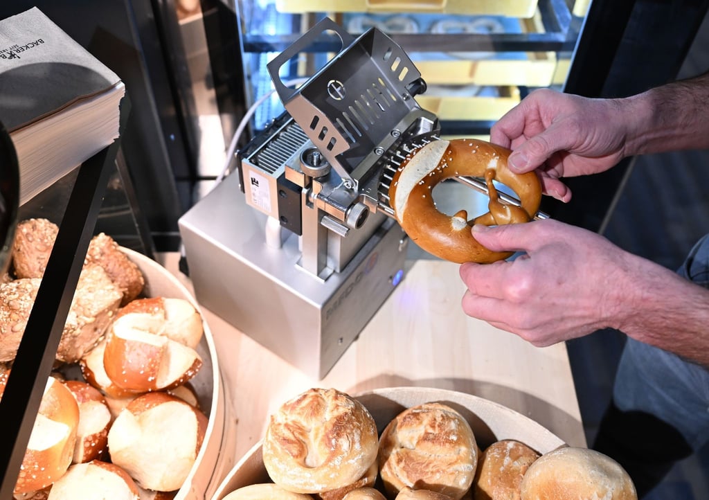 Mit der Brezel-Befüllungsmaschine wird per Knopfdruck die Butter in die Brezel gespritzt.