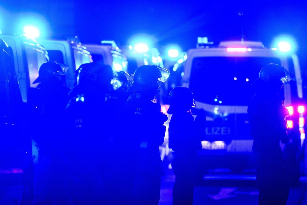 Polizisten stehen am Abend des 78. Jahrestages der Zerstörung Dresdens im Zweiten Weltkrieg zwischen Gegendemonstranten und einem Zug von Montagsdemonstranten in der Innenstadt.