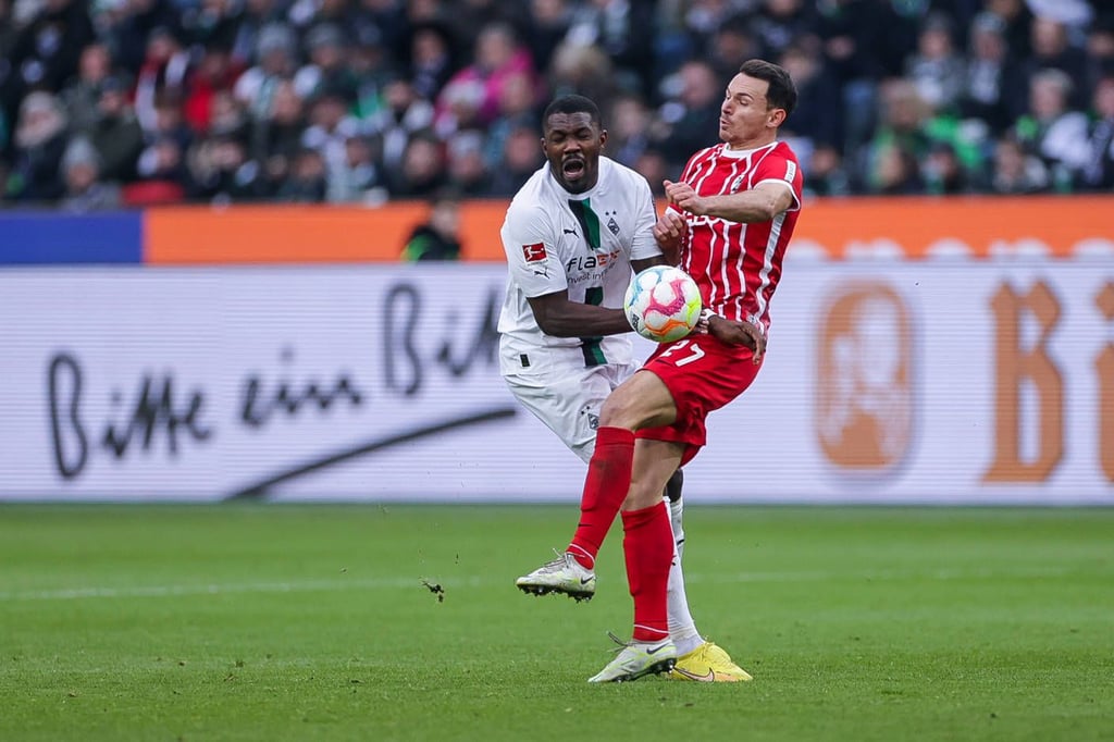 Marcus Thuram (Borussia Mönchengladbach) und Freiburgs Nicolas Höfler (r.) stoßen zusammen.