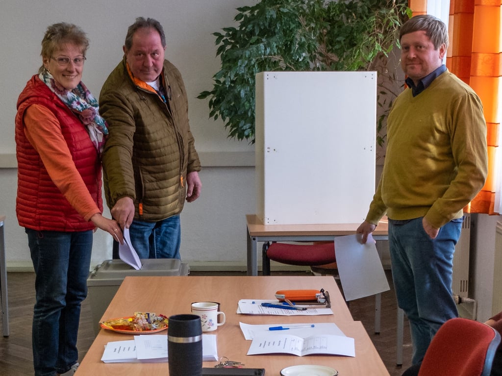 Kerstin und Hartmut Plaul geben in Luckenau ihre Stimmen ab, rechts von ihnen Wahlvorsteher Martin Dorniß.