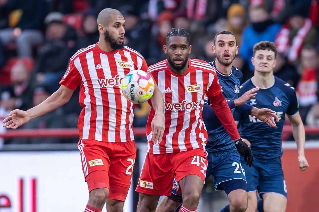 Berlins Aissa Laidouni (l-r) und Jordan Siebatcheu laufen zum Ball vor Ellyes Skhiri von FC Köln.