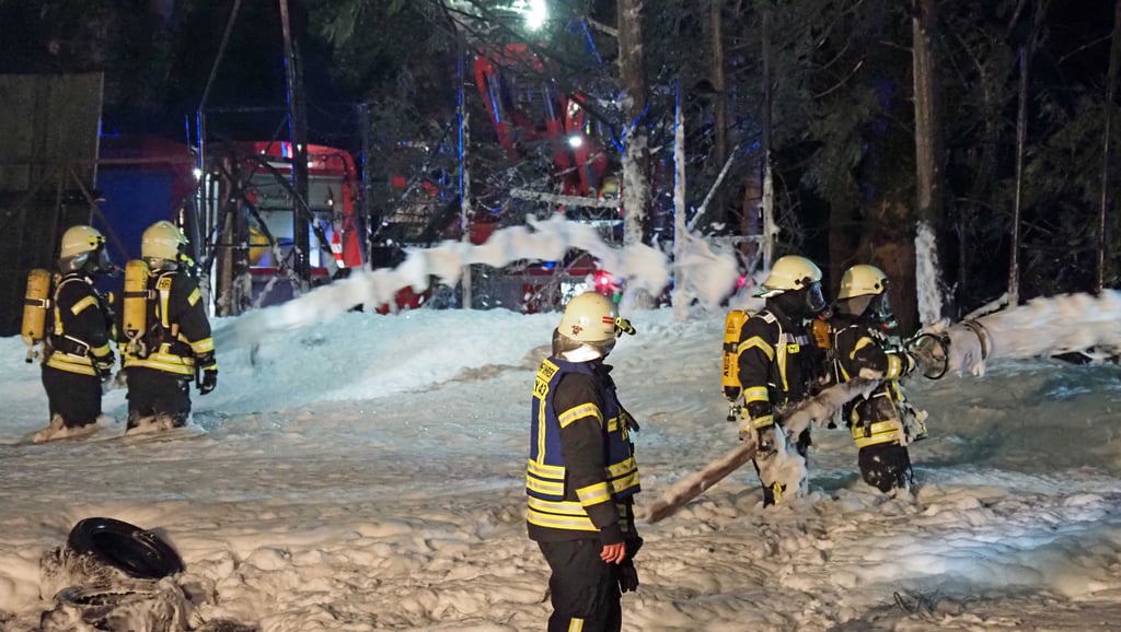 Mit einem riesigen Schaumteppich aus mehreren Rohren gelang es Einsatzkräften, das Feuer im Reifenstapel zu ersticken. Durch die Drehleiter im Hintergrund wurde der Bereich dafür ausgeleuchtet.