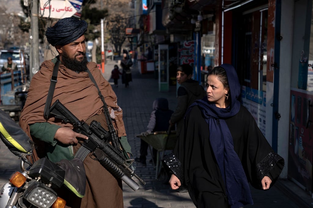 Mit kritischem Blick geht eine Frau in Kabul an einem Taliban-Kämpfer vorbei. Die Islamisten machen bisher keine Anstalten, älteren Mädchen und Frauen den Zugang zu Bildungseinrichtungen zu gewähren.