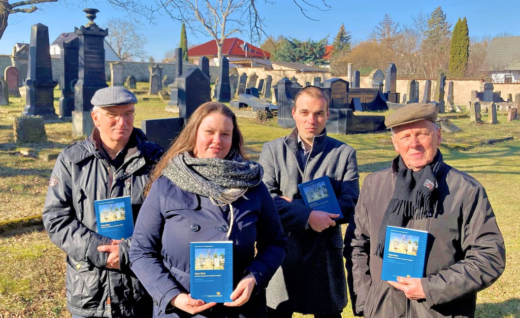 Die anhaltischen Autoren Joachim Grossert (von links, Arbeitskreis Jüdische Geschichte in Bernburg), Anett Gottschalk (Museum Synagoge Gröbzig), Aaron Russ (Jüdische Gemeinde Dessau-Roßlau) und Bernd G. Ulbrich (Moses-Mendelssohn-Gesellschaft Dessau-Roßlau) stellen auf dem jüdischen Friedhof in Bernburg die Publikation „Gute Orte - jüdische Grabstätten in Sachsen-Anhalt" vor.