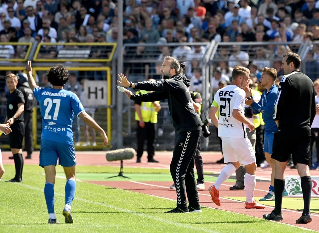 Oldenburgs Trainer Dario Fossi (M) gibt Anweisungen am Spielfeldrand.