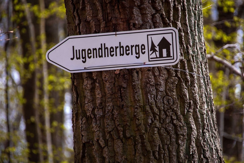 Blick auf einen Wegweiser zu einer Jugendherberge.