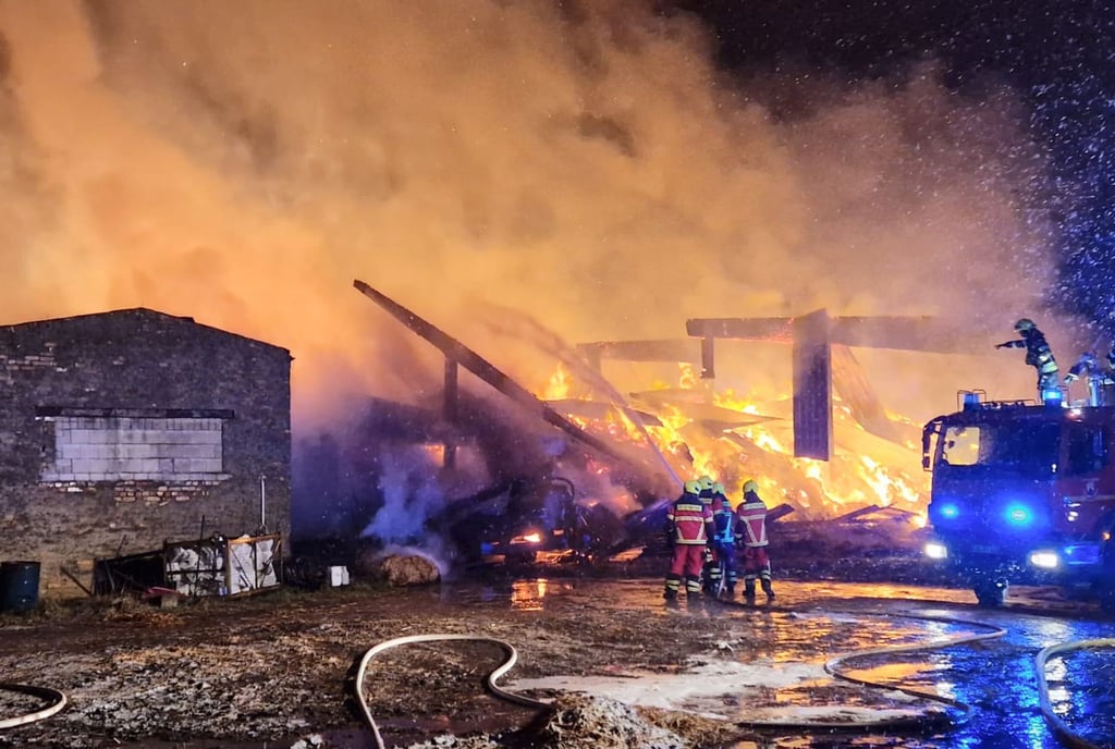 Feuerwehrleute sind bei einem Scheunenbrand in Werneuchen im Einsatz.