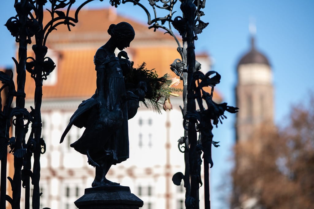 Die Brunnenfigur „Gänseliesel“ ist vor dem Turm der St. Jacobi-Kirche zu sehen.
