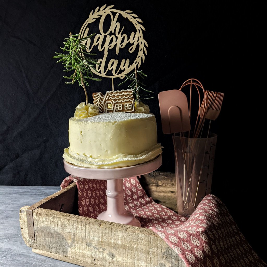 Die mit Buttercreme eingestrichene Weihnachtstorte bekommt als Deko einen Spekulatius und zwei Rosmarinzweige und sieht damit wie eine Winterlandschaft aus.