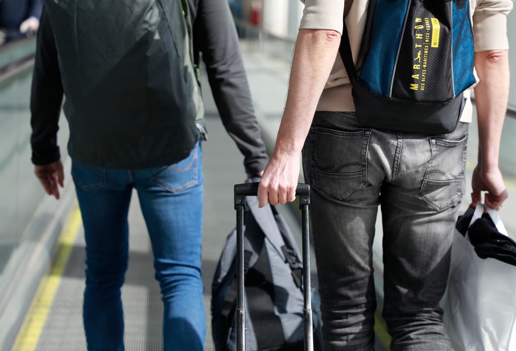 Touristen mit Koffern im Flughafen.