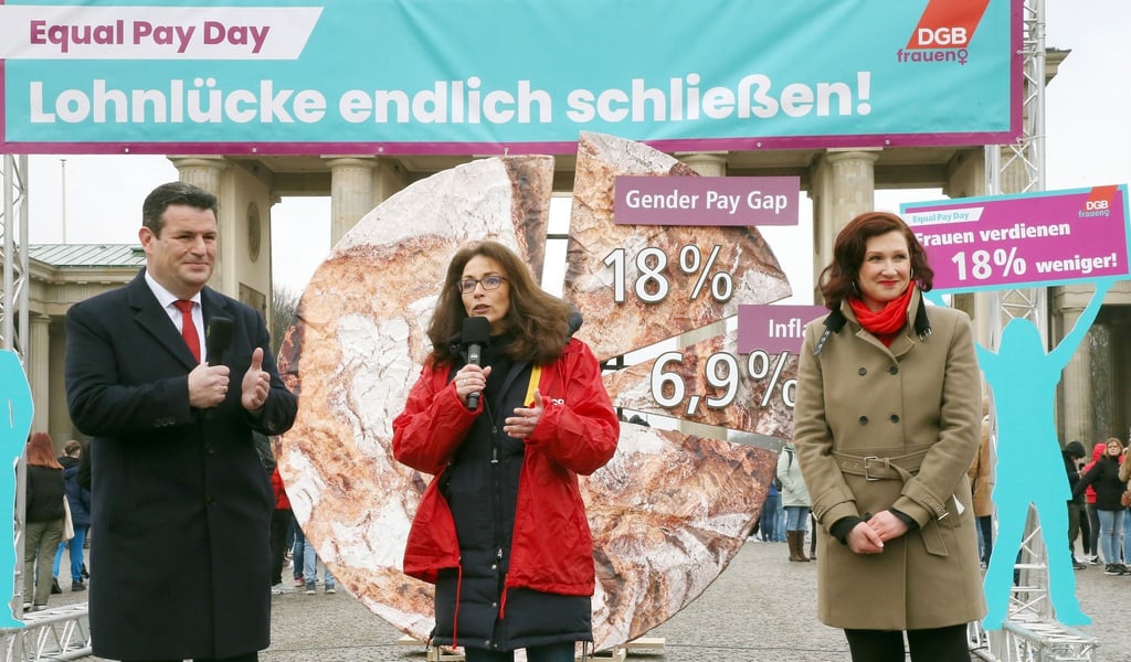 Die DGB-Vorsitzende Yasmin Fahimi (M) gibt am Vortag des Internationalen Frauentages ein Statement zum Equal Pay Day vor dem Brandenburger Tor ab. Neben ihr: Bundesarbeitsminister Hubertus Heil.