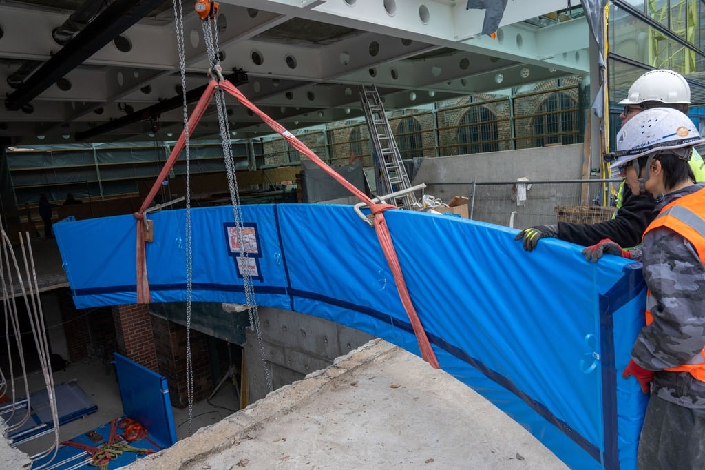 Mitarbeiter einer Spezialfirma transportieren auf der Baustelle des Meeresmuseums eine über sechs Meter lange Acrylglasscheibe aus Japan.