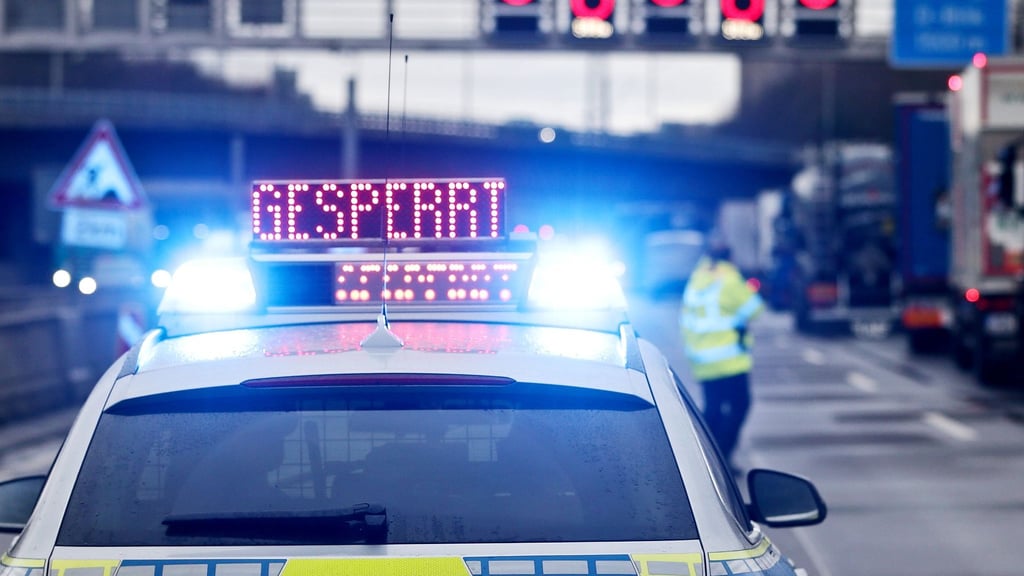 Auf einem Polizeifahrzeug leuchtet die Aufschrift „Gesperrt“.