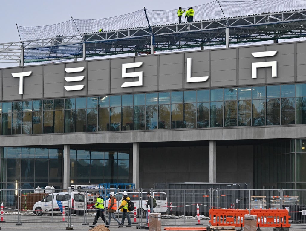 Arbeiter gehen über das Werksgelände der Tesla-Fabrik.