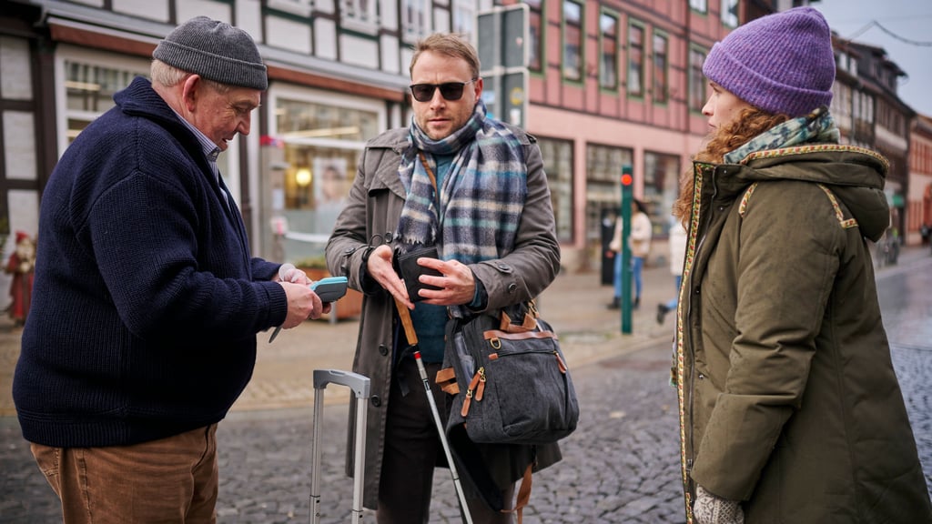 Ein Taxi zur Bescherung wurde im Februar 2022 in Wernigerode gedreht. Taxifahrer Axel Parschke (Dietmar Bär, l.) kassiert von seinem Fahrgast Jan Olsmer (Max Riemelt, M.) Geld. Jenny Fellers (Marlene Tanczik, r.) ist fassungslos: Sie hat gerade realisiert, dass Jan blind ist.