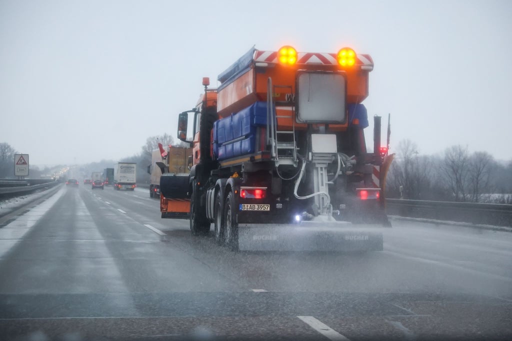 Ein Streufahrzeug fährt auf der A9 bei Schkeuditz und verteilt Salz auf der Fahrbahn.