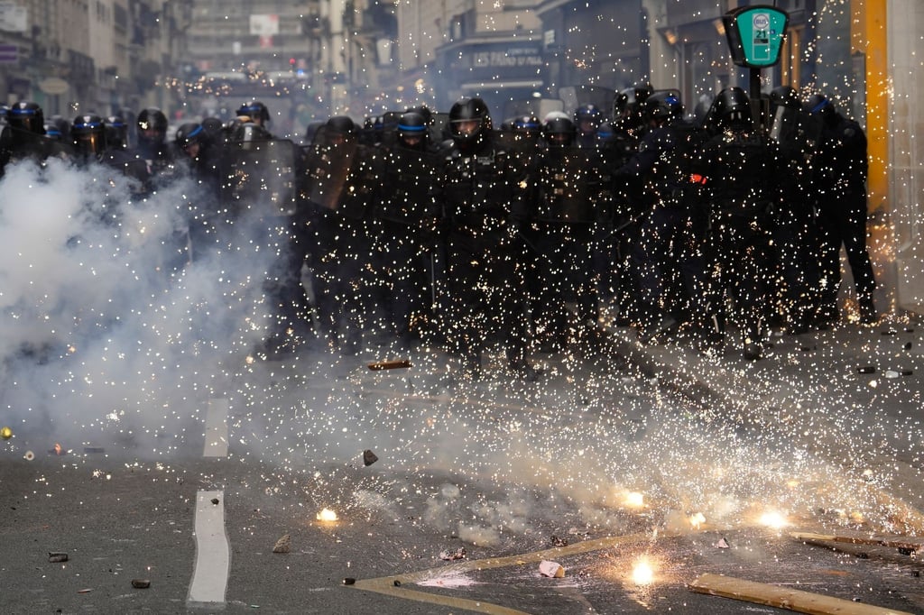 Bereitschaftspolizisten stoßen in Paris mit Demonstranten zusammen.