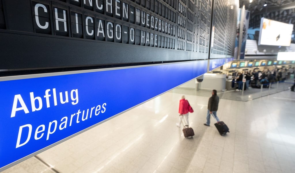 Reisegäste gehen an einem Flughafen zum Abflugterminal.