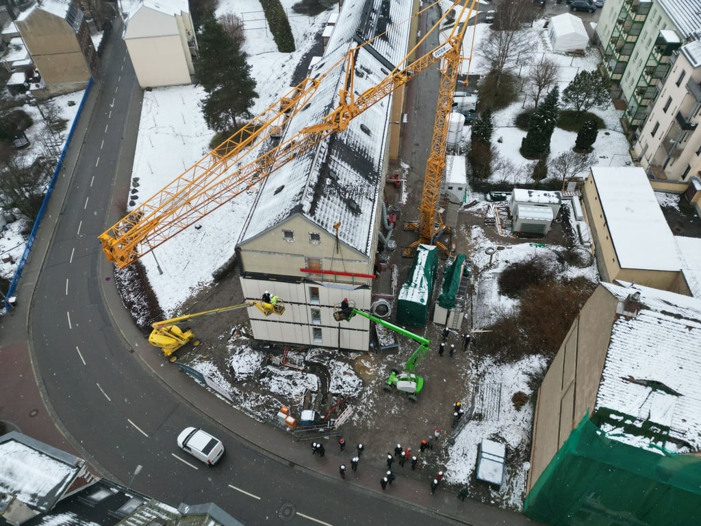 Energetisch ertüchtigte Fassadenmodule werden an einem Wohnblock montiert.