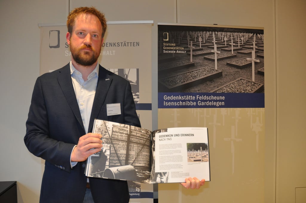 Lukkas Busche vom Gedenkstättenteam mit dem neuen Katalog zur Dauerausstellung, der ab sofort im Dokumentationszentrum erhältlich ist.
