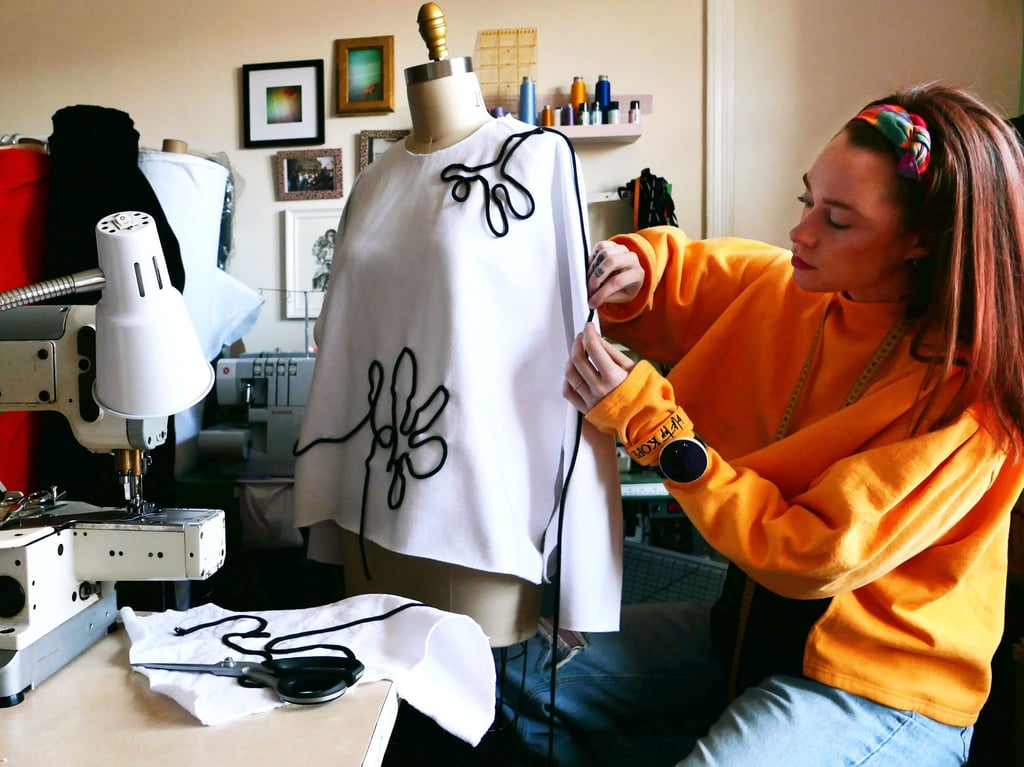 Die deutsche Mode-Schneiderin Janina Klahold arbeitet an einer Kreation, die auf einer Kleiderpuppe in ihrem Nähzimmer hängt.